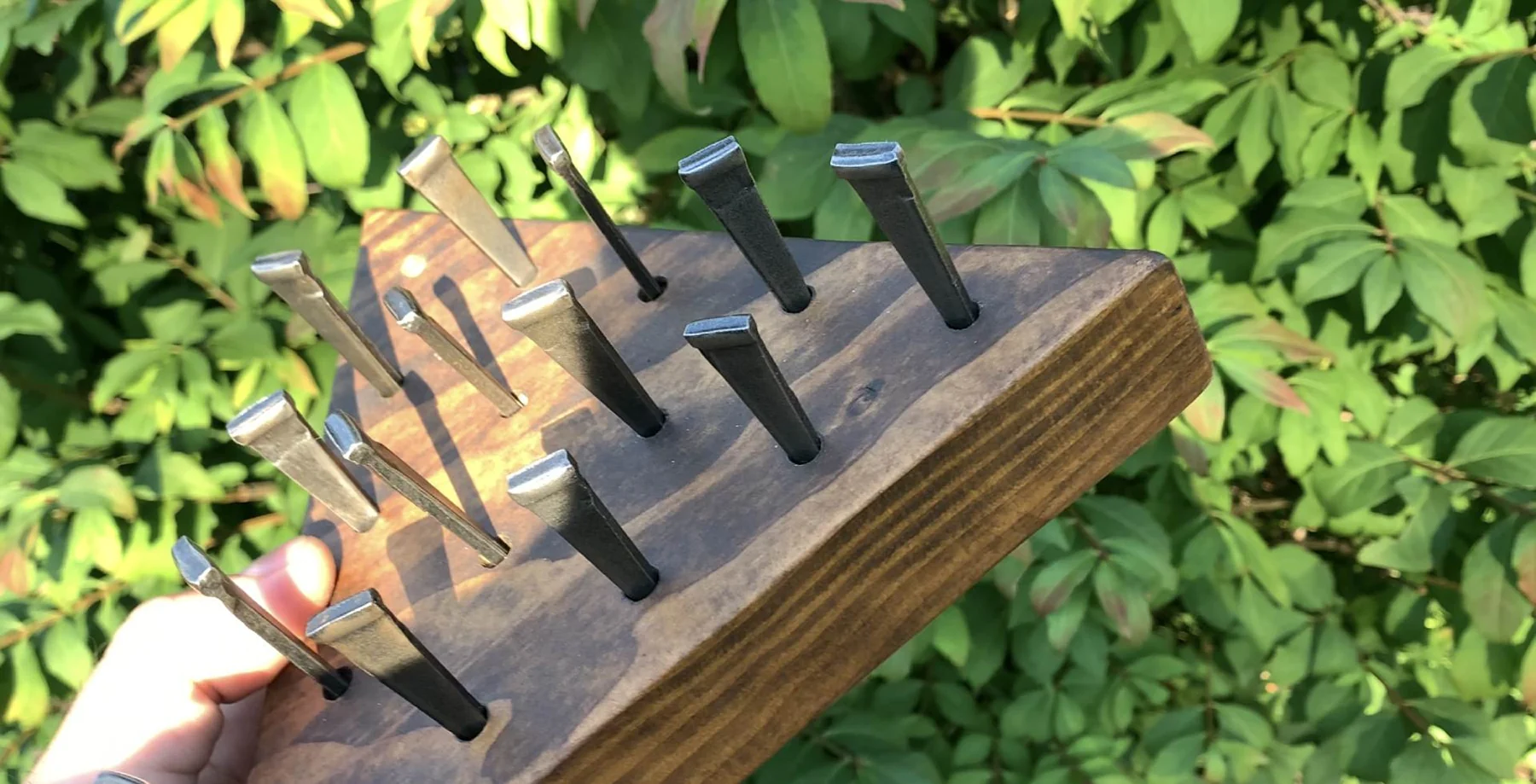 Original Triangle Peg Game showing real wooden board and metal pegs